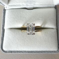 an emerald cut diamond ring in a velvet box