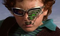 a young boy wearing sunglasses with futuristic technology attached to his face and eyeglasses