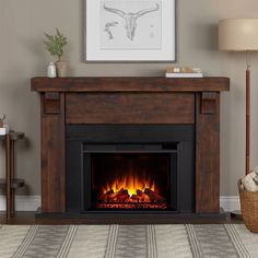 a living room with a fire place in the center and a painting on the wall