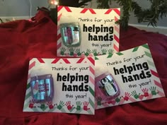 three handprinted greeting cards on top of a bed with christmas lights in the background