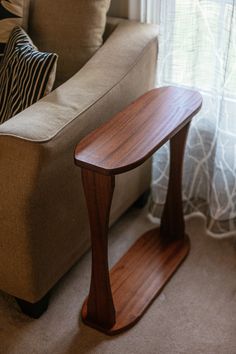 a wooden table sitting on top of a carpeted floor in front of a couch