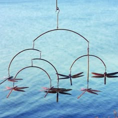 Display bold dragonflies in your landscaping using this Ancient Graffiti Copper Colored Hanging Dragonflies Mobile. These striking insect shapes lend a wetland motif to your garden, while also highlighting the beauty of wind. Staggered steel arches connect together with beaded chains, and each holds a three dimensional dragonfly shape. A top "S" hook makes it simple to place the frame on a hanger or tree branch, and the unique design moves easily in the wind for a fantastic mobile. The recogniza Dragonfly Decor, Dragonfly Art, Garden Items, Garden Ornaments, Garden Gifts, Dragonflies, Suncatchers