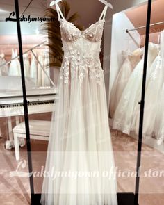 a wedding dress is on display in a store window, with other dresses behind it