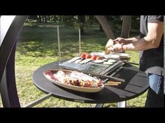 a man grilling food on top of a bbq with tongs in his hand