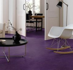 a living room with purple carpet and white furniture