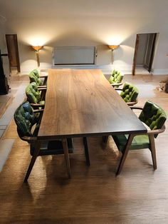 a large wooden table with green chairs around it