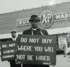 a black and white photo of a man holding a sign that says, do not buy where you will not be fired