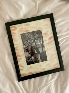 a black and white photo frame with a horse in the background on a bed sheet