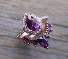 A Swoon-Worthy 2 Piece Bridal Ring Set features a Shimmery Teardrop Faceted 7mm x 5mm Purple Amethyst Halo Engagement Ring paired with a Purple Amethyst Contour Wedding Band handcrafted in your choice of metal such as Sterling Silver, Rose Plated/Gold Plated Silver or Solid 14k Gold is simply divine! Our Engagement Ring Set will have her swooned as it is a very unique ring set. It comes with a Ring Box ready for gift-giving. Engagement Ring Info ---------------------- Metal: Sterling Silver, Ros Pear Halo, Contour Wedding Band, Colored Engagement Rings, Silver Ring Set, Curved Wedding Band, Bridal Ring Set