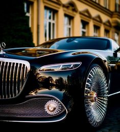 a black car parked in front of a building with gold trimmings on it