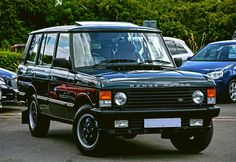 a range rover parked in a parking lot next to other cars