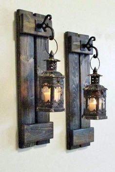 two lanterns are hanging on the wall next to each other, one is lit up