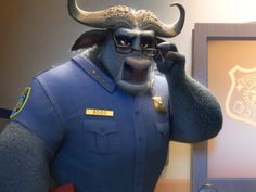 a statue of a bull wearing glasses and a police uniform is talking on the phone