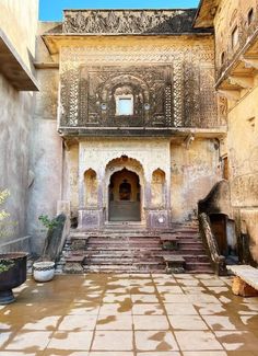 an old building with steps leading up to the door and windows on each side, in india