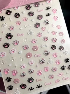 pink and black dog paw print stickers on a white sheet with the word love