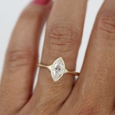 a woman's hand with a ring on it and a diamond in the middle