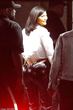 a woman in black leather pants and white shirt