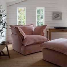 a pink chair and ottoman in a white room