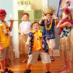 some kids are standing on the floor and one boy is holding a stick in his mouth