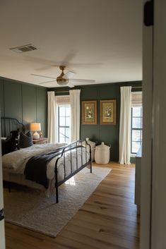 Dark green master bedroom with board and batten. House Design Moody, Light Bedroom Dark Accents, Vintage Area Rug Bedroom, Airy Master Bed, Chair Rail Bedroom Two Tones, Edgy Green Bedroom, Unique Home Styles, Dark Green Walls Bedroom Decor, Guest Bath Accent Wall