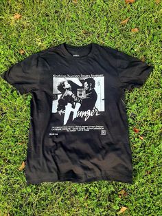 a black t - shirt laying on top of green grass