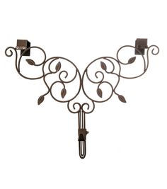 a wrought iron wall mounted hook with two candle holders on each side and an ornate scroll design