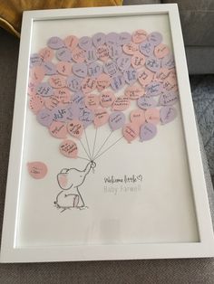 a white frame with pink and purple hearts attached to it, holding a balloon that says welcome little puppy