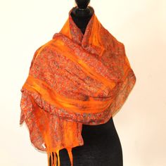 Stay cozy and stylish with this beautiful handmade shawl, crafted from a luxurious blend of recycled silk and merino wool. Soft and  unique piece of textile art features a bold, colorful design that is sure to turn heads. The shawl is made using a felting technique that involves layering silk and wool fibers and wet-felting them together by hand. This process creates a dense, soft fabric that drapes beautifully and is incredibly warm and cozy.  Measuring approximately 70 inches length and 12 inches width,  this shawl is large enough to wrap around your shoulders or wear as a scarf. It's perfect for adding a pop of color to any outfit, and the one-of-a-kind design ensures that you'll stand out from the crowd. Whether you're looking for a special gift for a loved one or a unique addition to Orange Bohemian Shawl For Fall, Handmade Wool Scarves In Bohemian Style, Bohemian Wool Scarves Handmade, Bohemian Handmade Wool Scarves, Bohemian Shawl Scarf With Natural Dye, Bohemian Shawl Scarves With Natural Dye, Bohemian Silk Scarves One Size, Artisan Shawl For Fall, Bohemian Orange Silk Dupatta