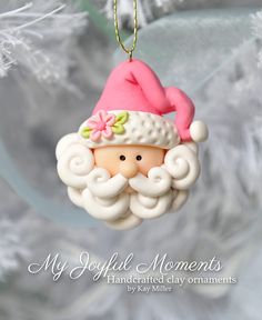 a christmas ornament with a pink hat and beard on it's head