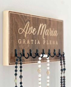 a wooden sign with beads hanging from it's sides and the words ape marina gratia plena