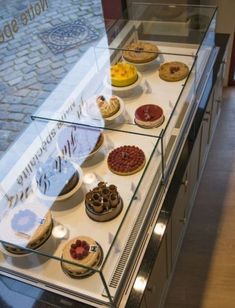 a display case filled with lots of different types of pastries on top of a counter