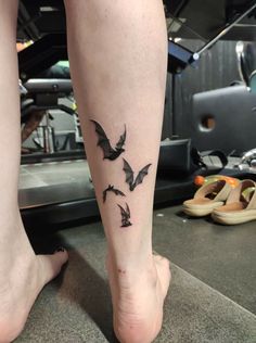 a person with a tattoo on their leg that has birds flying in the sky above them