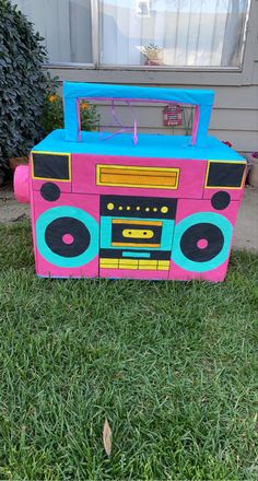 a pink and blue boombox sitting in the grass