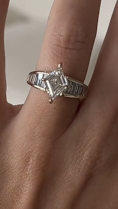 a woman's hand with a diamond ring on it