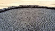 a knitted rug sitting on top of a wooden floor