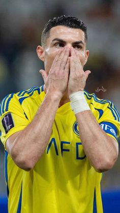 a soccer player covers his face with his hands