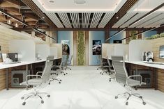 an office with multiple desks and chairs on each side of the room, all in white