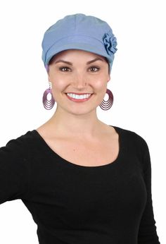 a woman wearing a purple hat and earrings