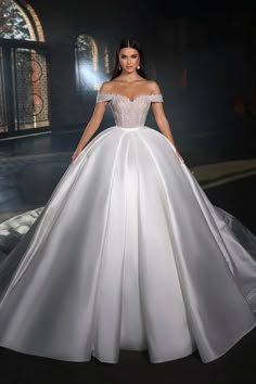 a woman in a white ball gown posing for the camera