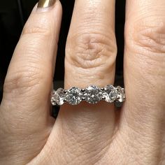 a woman's hand with a diamond ring on her left and two diamonds in the middle