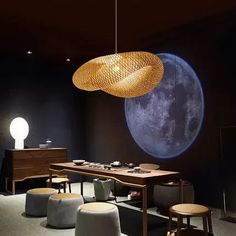 a room with chairs, tables and lights hanging from it's ceiling in front of an image of the moon