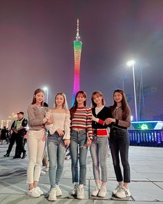 four girls standing in front of the eiffel tower