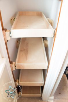 an open closet with shelves and drawers on the bottom shelf, next to a door