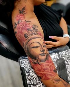 a woman with a buddha tattoo on her arm