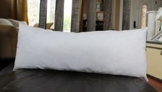 a white pillow sitting on top of a wooden table