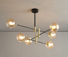 a chandelier hanging from the ceiling with five clear globes on each one