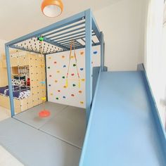 a child's bedroom with climbing wall and play area