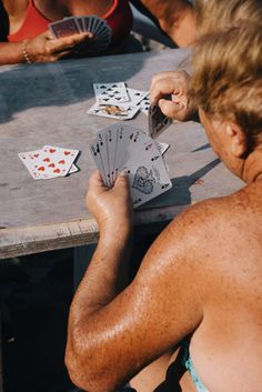 a person sitting at a table playing cards