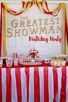 a circus themed birthday party with red and white striped tablecloths, cupcakes, candy