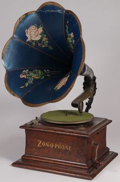 an antique phonographne is on top of a wooden stand